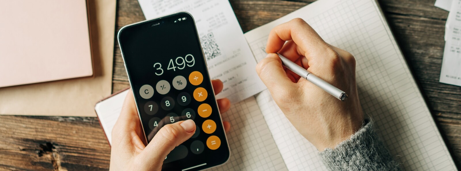 close-up of hands using the calculator app on a smartphone
