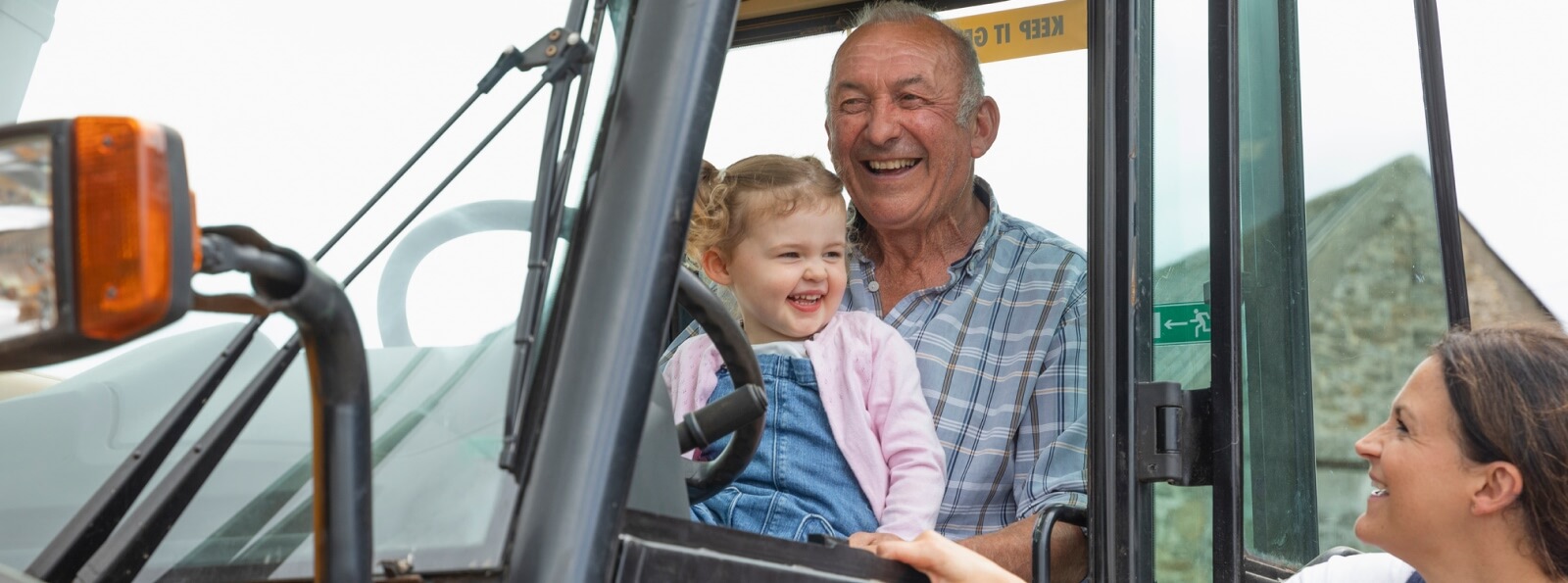 granddad holding toddler inside a tractor